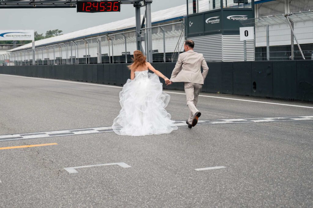 Hockenheimring Hochzeit - Brautpaar läuft über Start-Ziel fotografiert von HochzeitUndBild