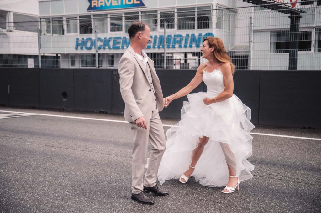 Hockenheimring Hochzeit - 2 -Glückliches Brautpaar auf der Zielgeraden fotografiert von HochzeitUndBild