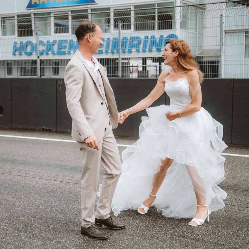 Hochzeit Hockenheimring - BrautpaarShooting Brautpaar freut sich vor HockenheimLogo