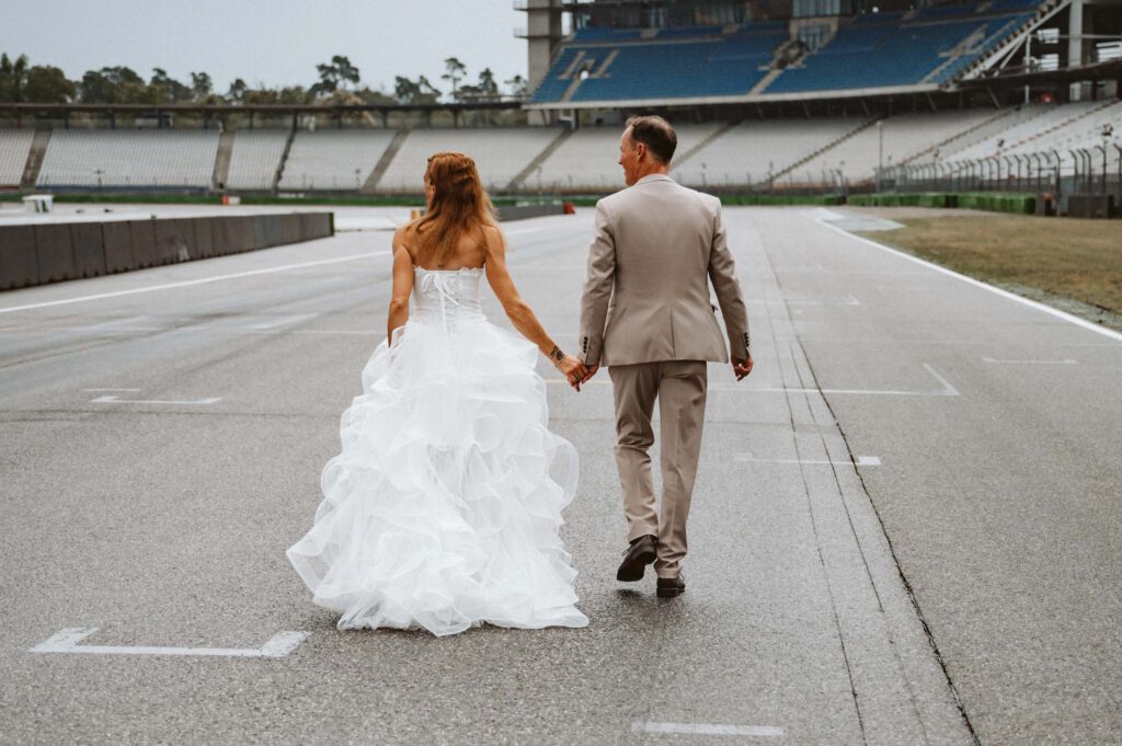 Hochzeit Hockenheimring - BrautpaarShooting Brautpaar jubelnd auf Rennstrecke