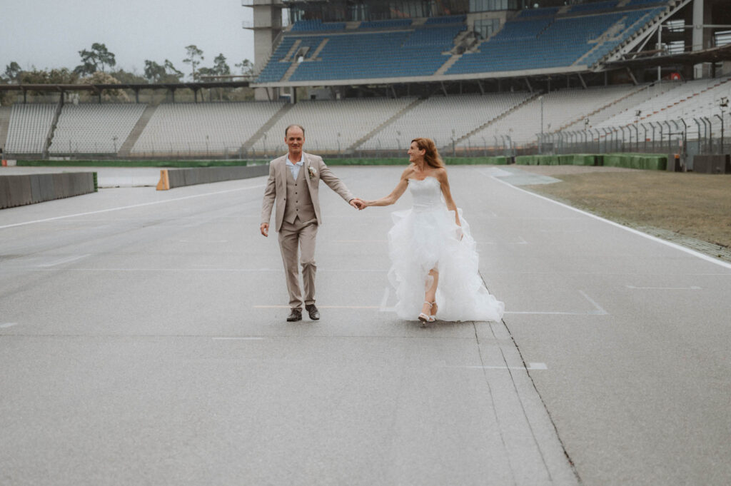 Hochzeit Hockenheimring - BrautpaarShooting Brautpaar laeuft auf Rennstrecke B