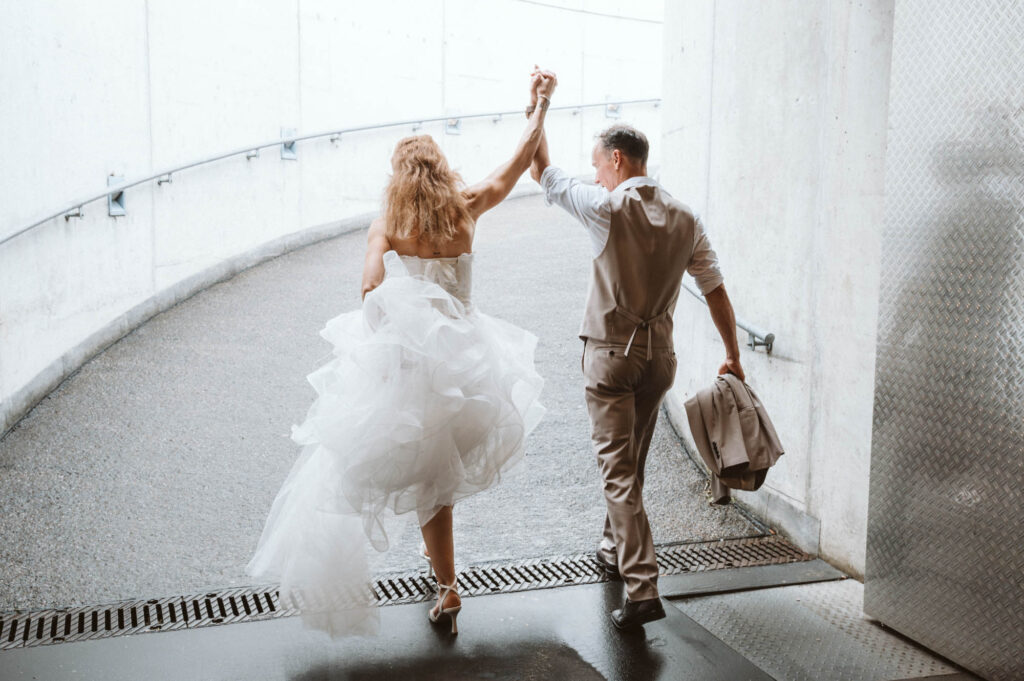 Hochzeit Hockenheimring - BrautpaarShooting Brautpaar laeuft jubelnd unter Rennstrecke durch