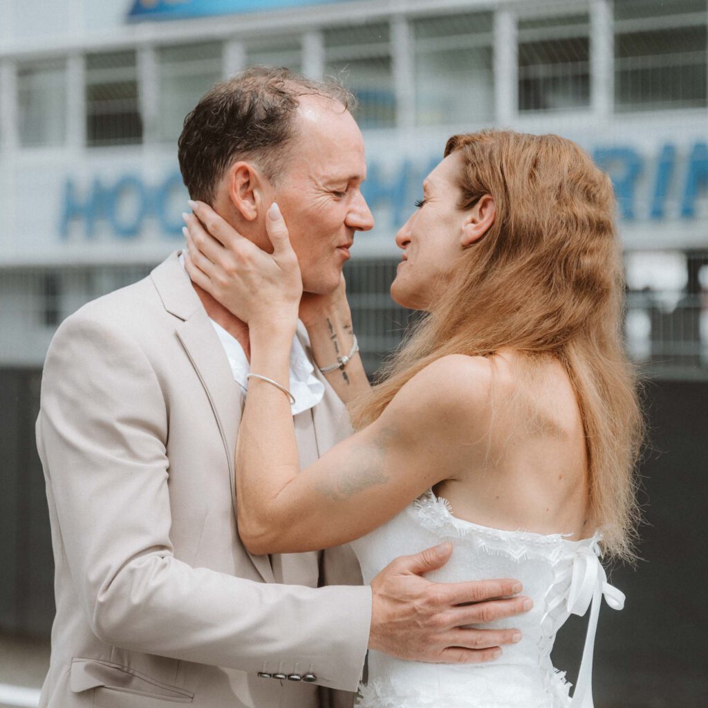 Hochzeit Hockenheimring - BrautpaarShooting Brautpaar umarmt sich vor HockenheimLogo