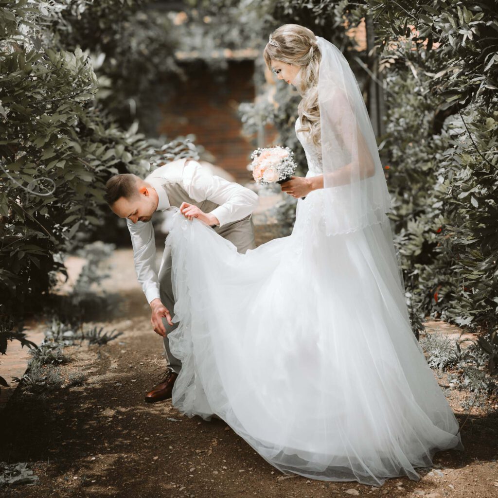 Hochzeitsfotograf Heidelberg_Brautpaarshootign Braeutigam ordnet Brautkleid Q_005