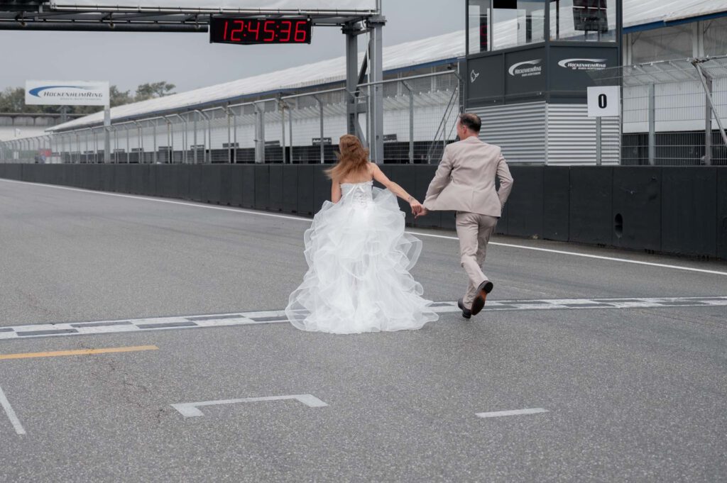 Hochzeitsfotograf Hockenheimring_BrautpaarShooting Brautpaar rennt auf Rennstrecke_033