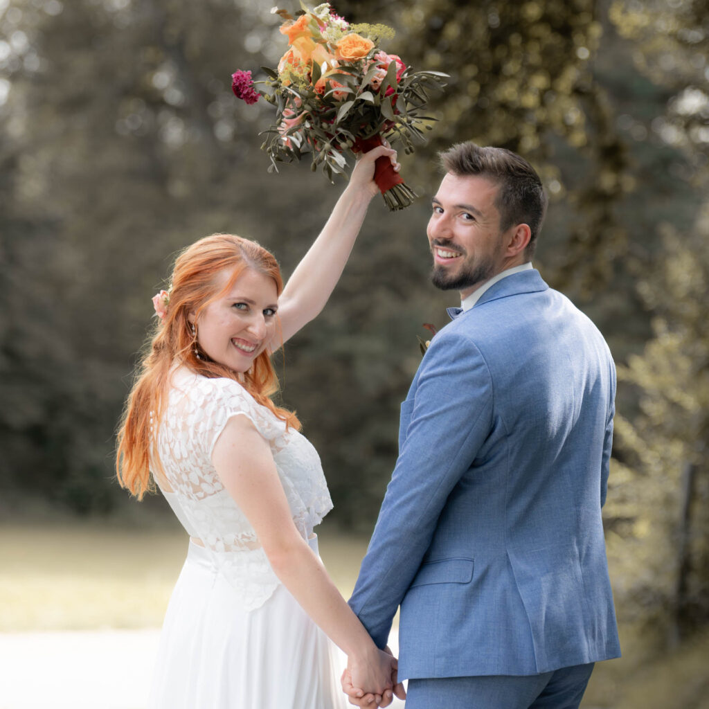 Hochzeitsfotograf Heidelberg - BrautpaarShooting Brautpaar reckt Brautstrauss hoch v250606