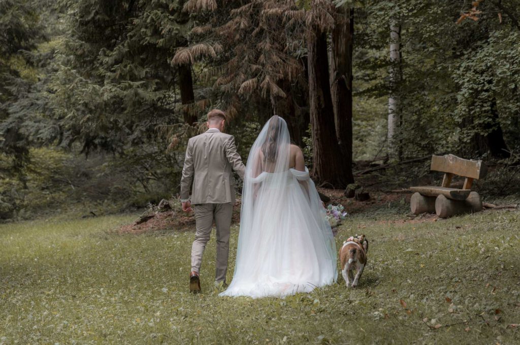 Brautpaarshooting - das Paar läuft zu dritt mit Hund