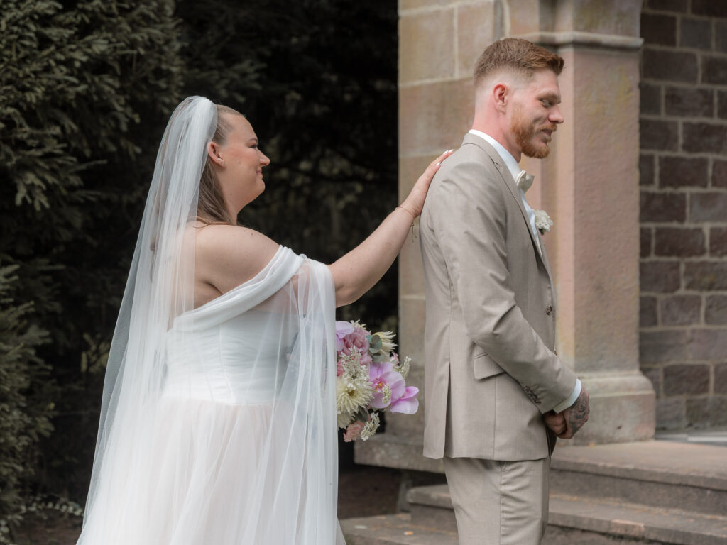 Die Braut berührt den Bräutigam beim First look